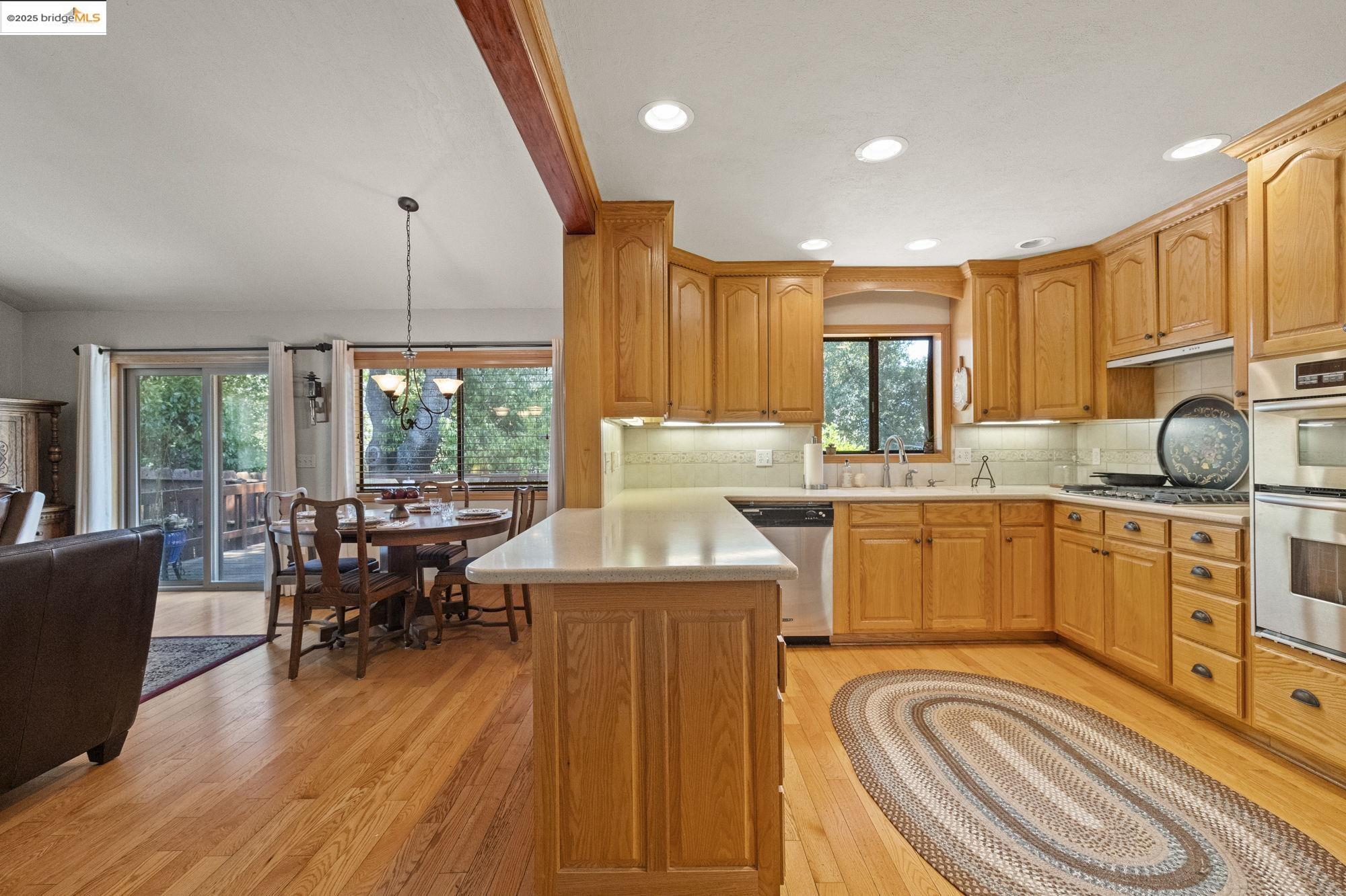 21645 La Vereda Road Sonora, CA 95370 - Photo 8 of 32 a kitchen with stainless steel appliances granite countertop sink stove and wooden cabinets