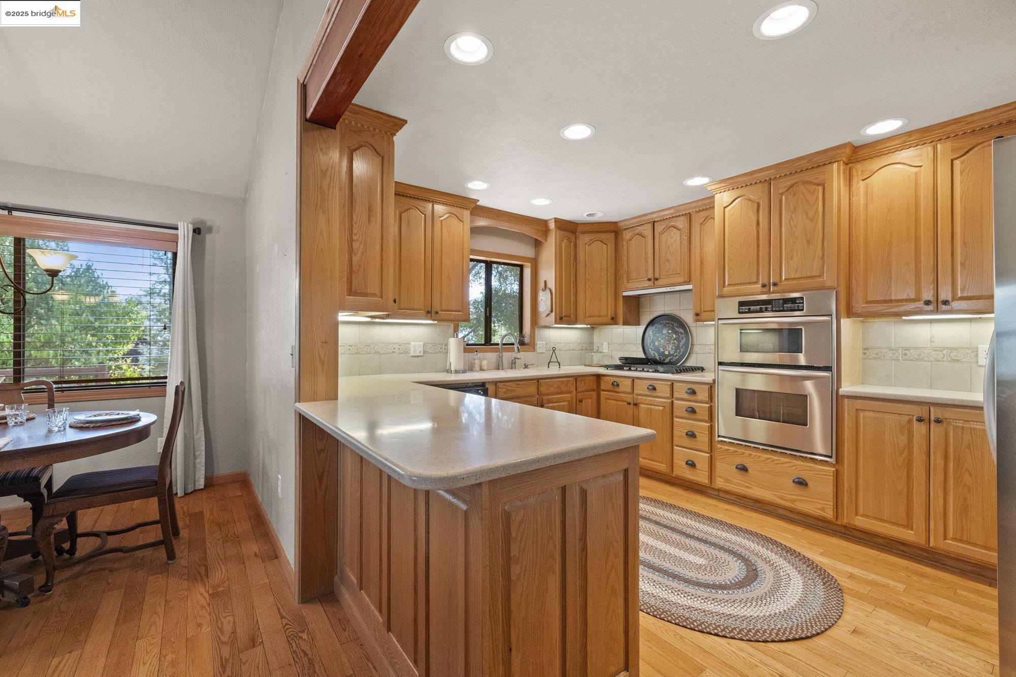 21645 La Vereda Road Sonora, CA 95370 - Photo 9 of 32 a kitchen with stainless steel appliances granite countertop a sink a stove a refrigerator cabinets and wooden floor