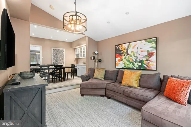 a living room with furniture a chandelier and a flat screen tv