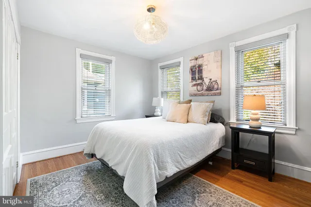 a bedroom with a bed and a window with chair