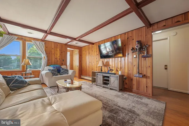 a living room with furniture a flat screen tv and a large window
