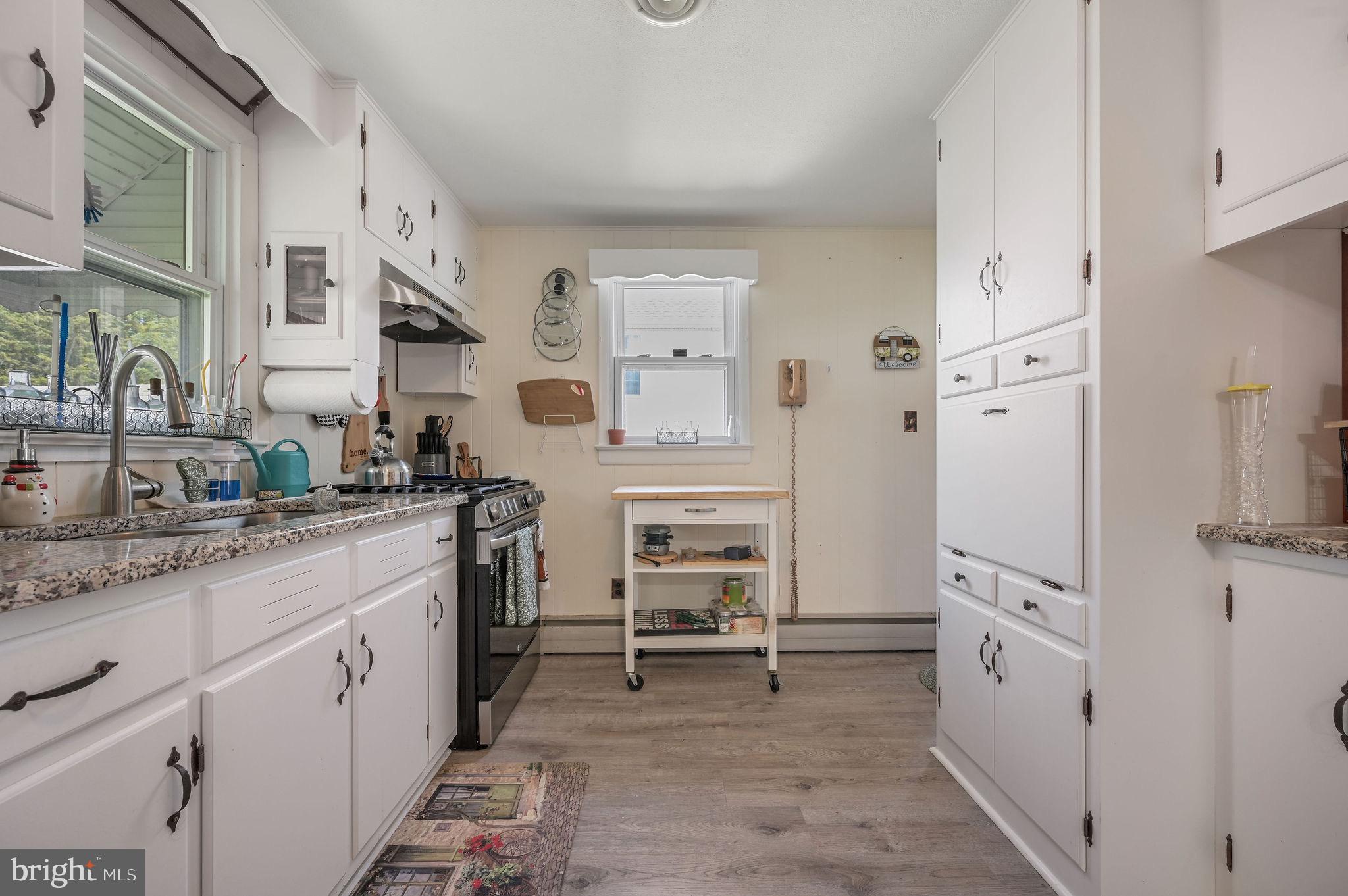11 Simpson Street Harrington, DE 19952 - Photo 15 of 29 a kitchen with white cabinets and white appliances