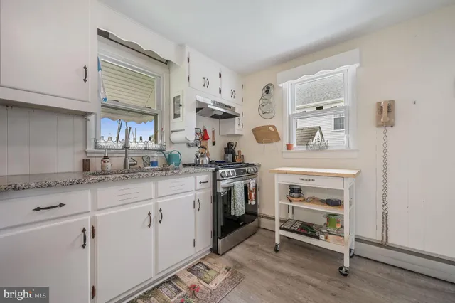 a kitchen with granite countertop a sink cabinets stainless steel appliances and a counter space