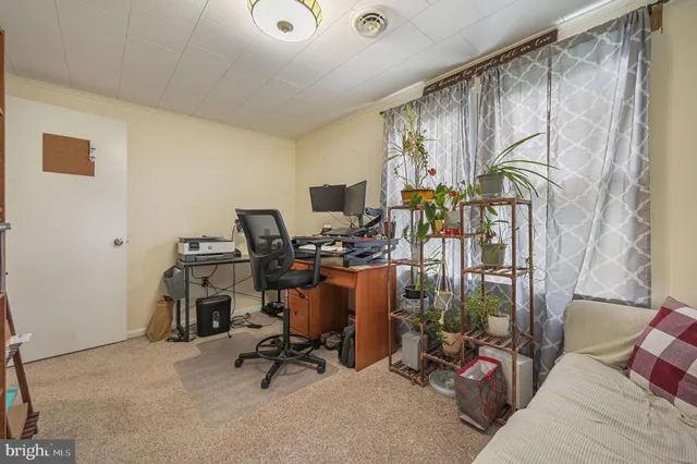 a view of a workspace with furniture and a window