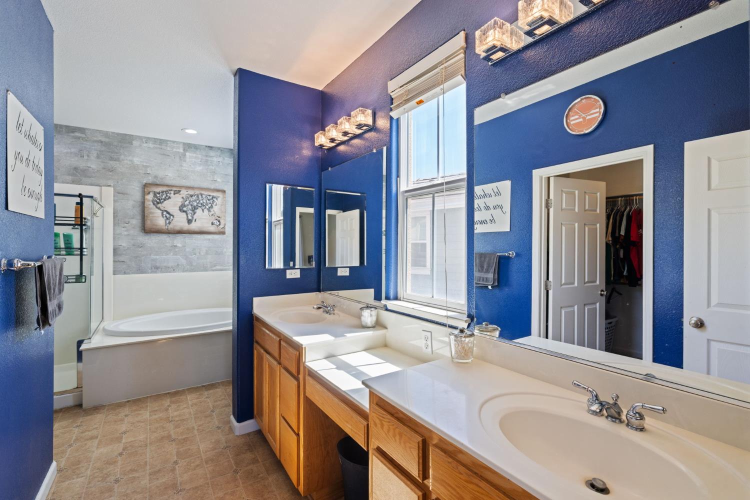 562 Ranger Street Oakdale, CA 95361 - Photo 36 of 64 Master bathroom featuring an oval tub, double sink vanity, a stall shower, and walk-in closet