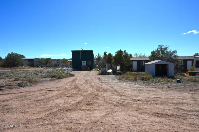 a view of a dry yard with wooden fence