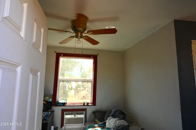 a room with a window and a ceiling fan
