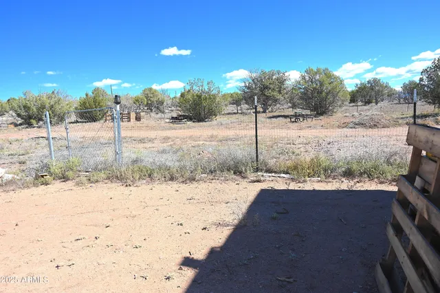 a view of a yard with wooden fence