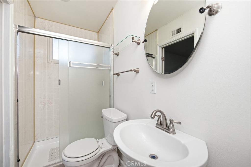 2490 Invar Court Simi Valley, CA 93065 - Photo 19 of 25 a bathroom with a sink a mirror a toilet and shower