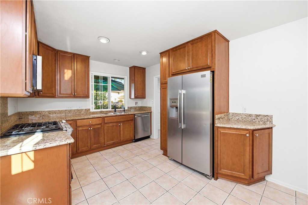 2490 Invar Court Simi Valley, CA 93065 - Photo 6 of 25 a kitchen with stainless steel appliances granite countertop a refrigerator a stove and a sink with granite countertops