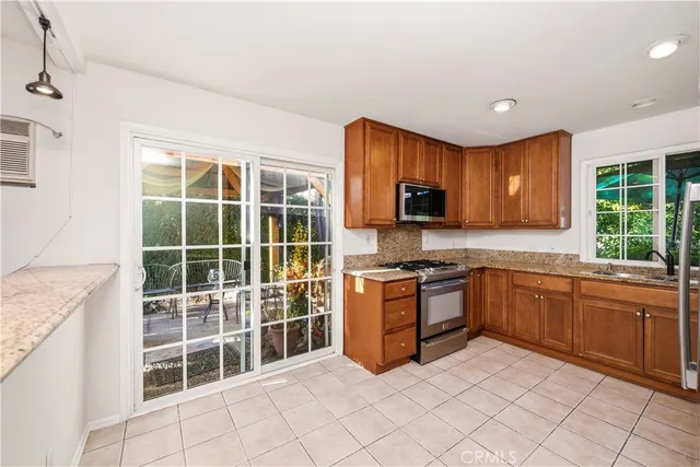 a kitchen with stainless steel appliances granite countertop a stove a sink dishwasher and a refrigerator
