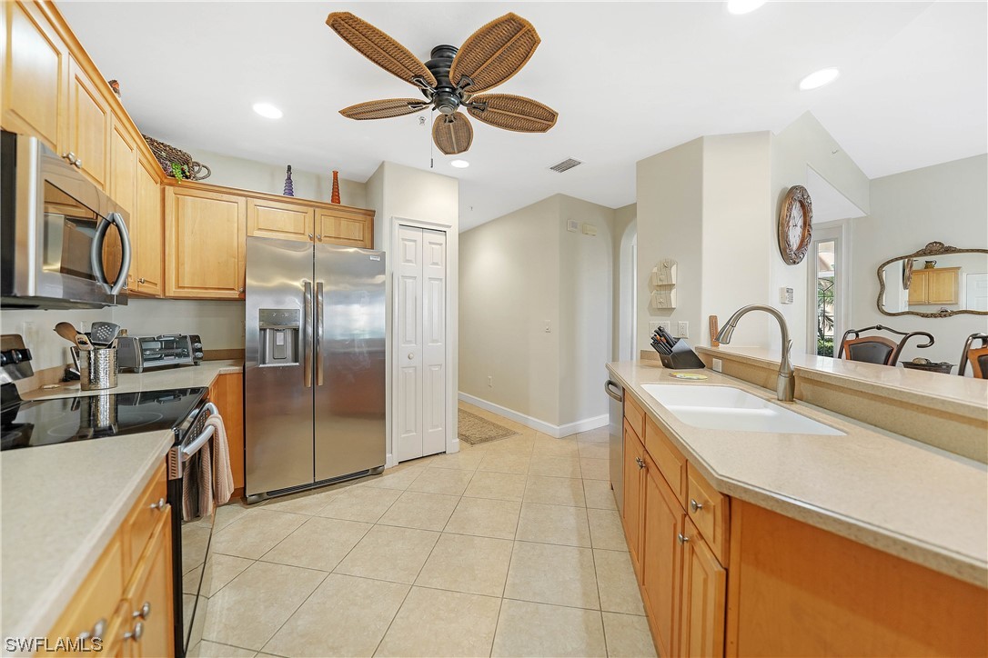 3228 Sunset Key Circle, Unit 101 Punta Gorda, FL 33955 - Photo 14 of 33 a kitchen with stainless steel appliances granite countertop a sink a stove a refrigerator cabinets and a dining table