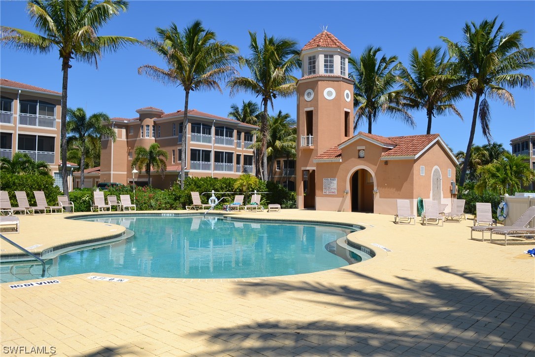 3228 Sunset Key Circle, Unit 101 Punta Gorda, FL 33955 - Photo 30 of 33 a view of a swimming pool with a chair and palm trees