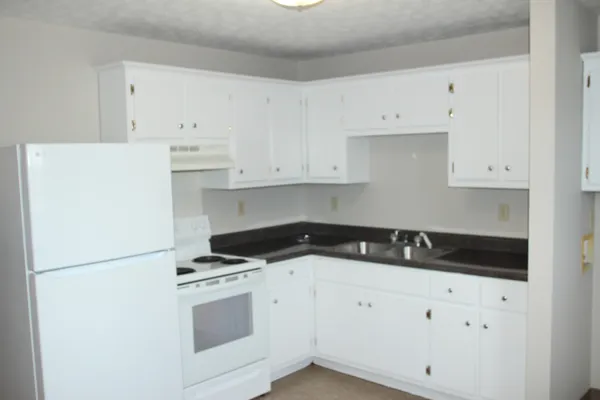 a kitchen with cabinets appliances a sink and a counter top