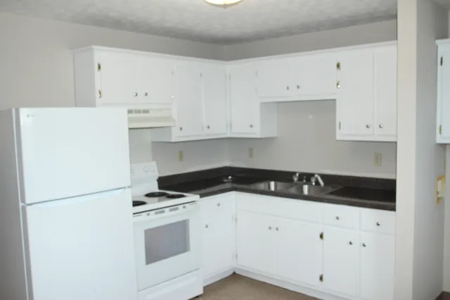 a kitchen with cabinets appliances a sink and a counter top