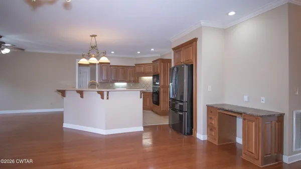 a view of a kitchen with refrigerator and wooden floor