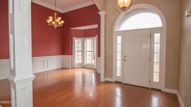 a view of a livingroom with wooden floor and a chandelier