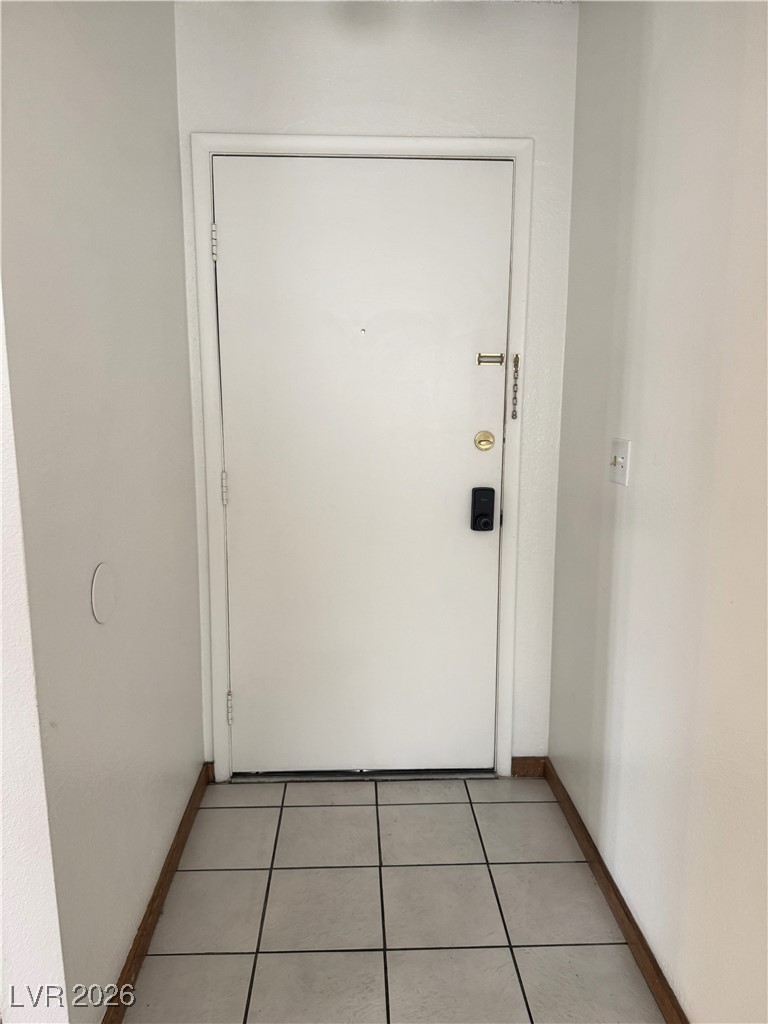 5311 South Sandhill Road Las Vegas, NV 89120 - Photo 17 of 24 Doorway to outside featuring tile patterned flooring and baseboards