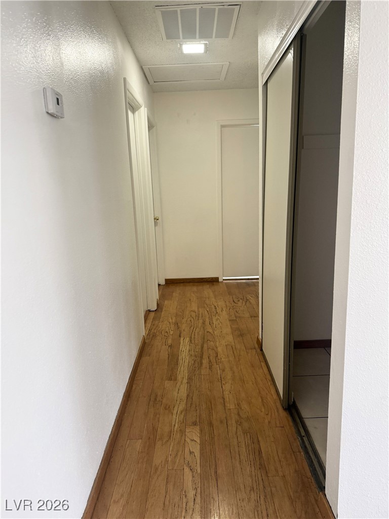 5311 South Sandhill Road Las Vegas, NV 89120 - Photo 18 of 24 Corridor with light wood-type flooring, a textured wall, and a textured ceiling