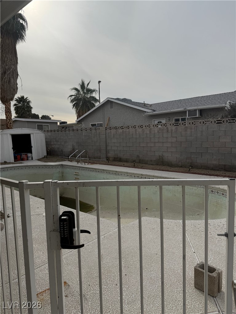 5311 South Sandhill Road Las Vegas, NV 89120 - Photo 21 of 24 View of pool with a fenced backyard and a storage unit
