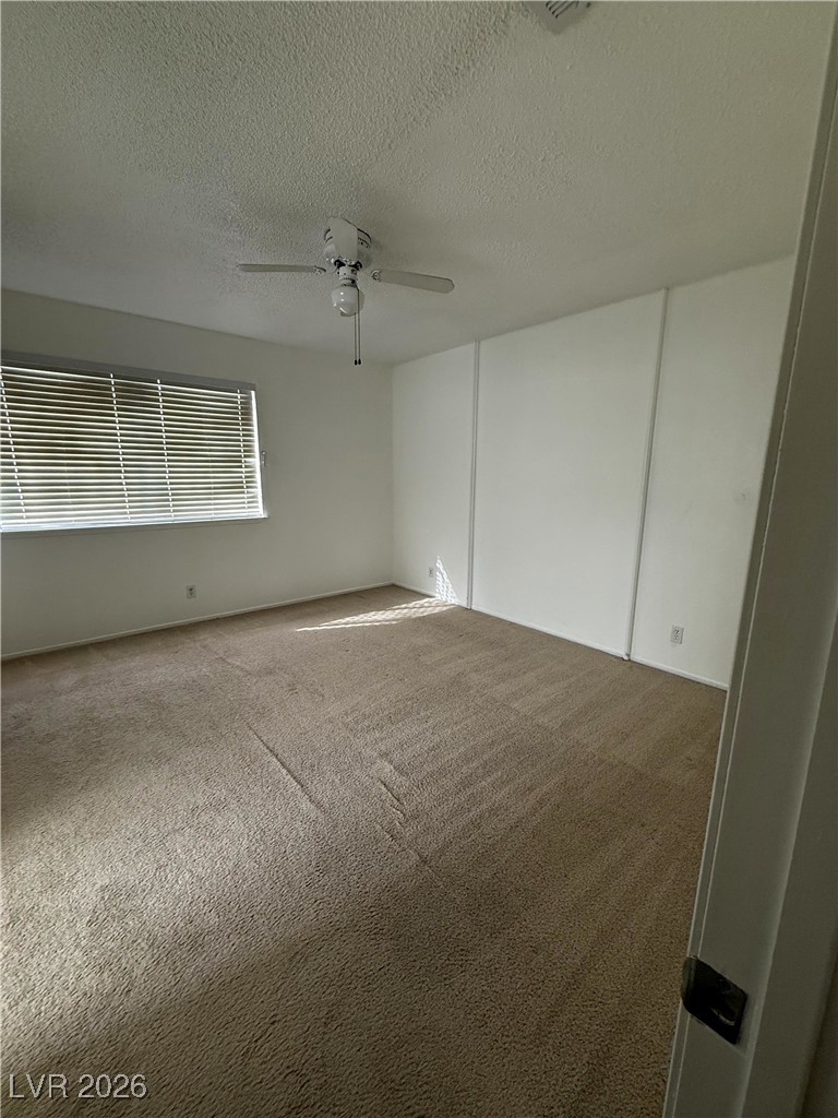5311 South Sandhill Road Las Vegas, NV 89120 - Photo 5 of 24 Carpeted empty room with a textured ceiling and a ceiling fan