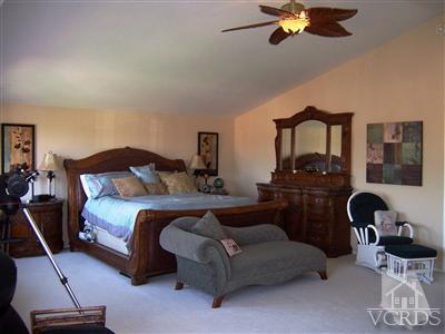 11699 Chestnut Ridge Street Moorpark, CA 93021 - Photo 12 of 20 a bedroom with a bed and a chandelier