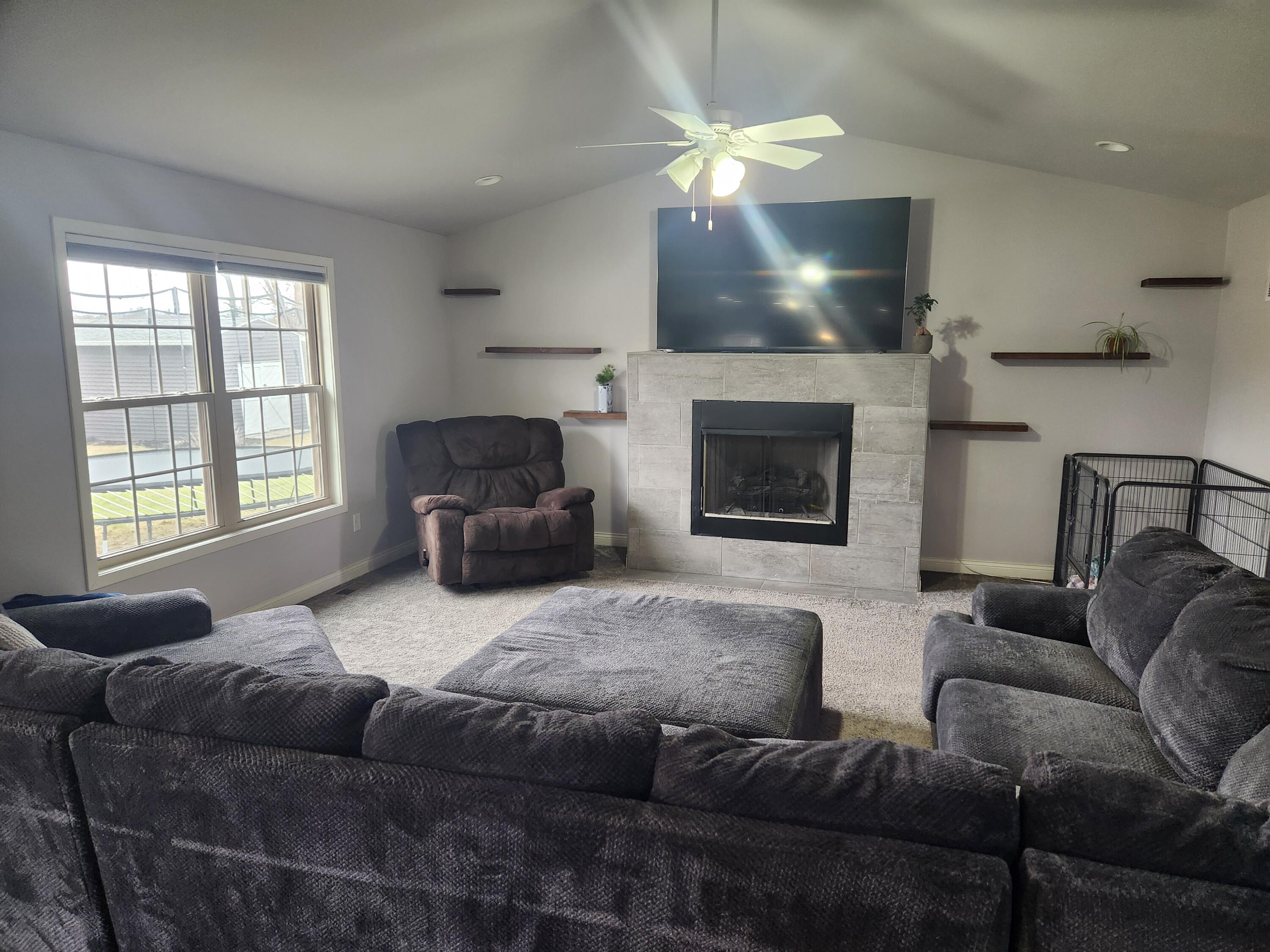 702 19th Street Southeast De Motte, IN 46310 - Photo 2 of 11 a living room with furniture a fireplace and a large window