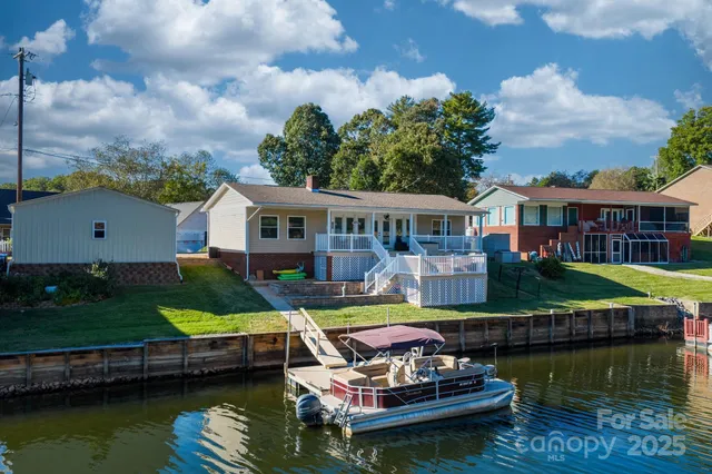 a small pool with lawn chairs under an umbrella