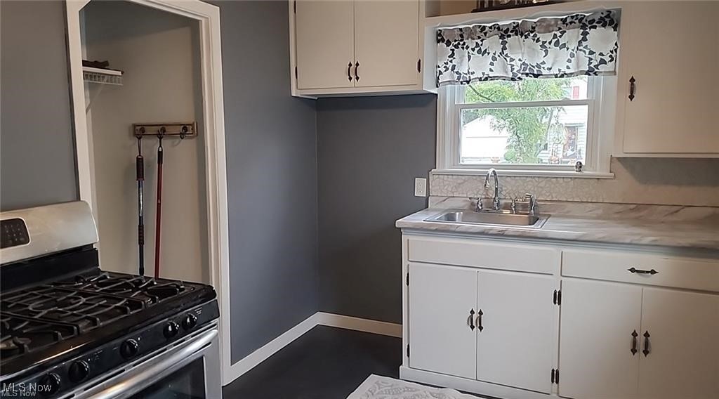 23621 Colbourne Road Euclid, OH 44123 - Photo 35 of 45 Kitchen featuring white cabinetry, sink, and stainless steel range with gas stovetop