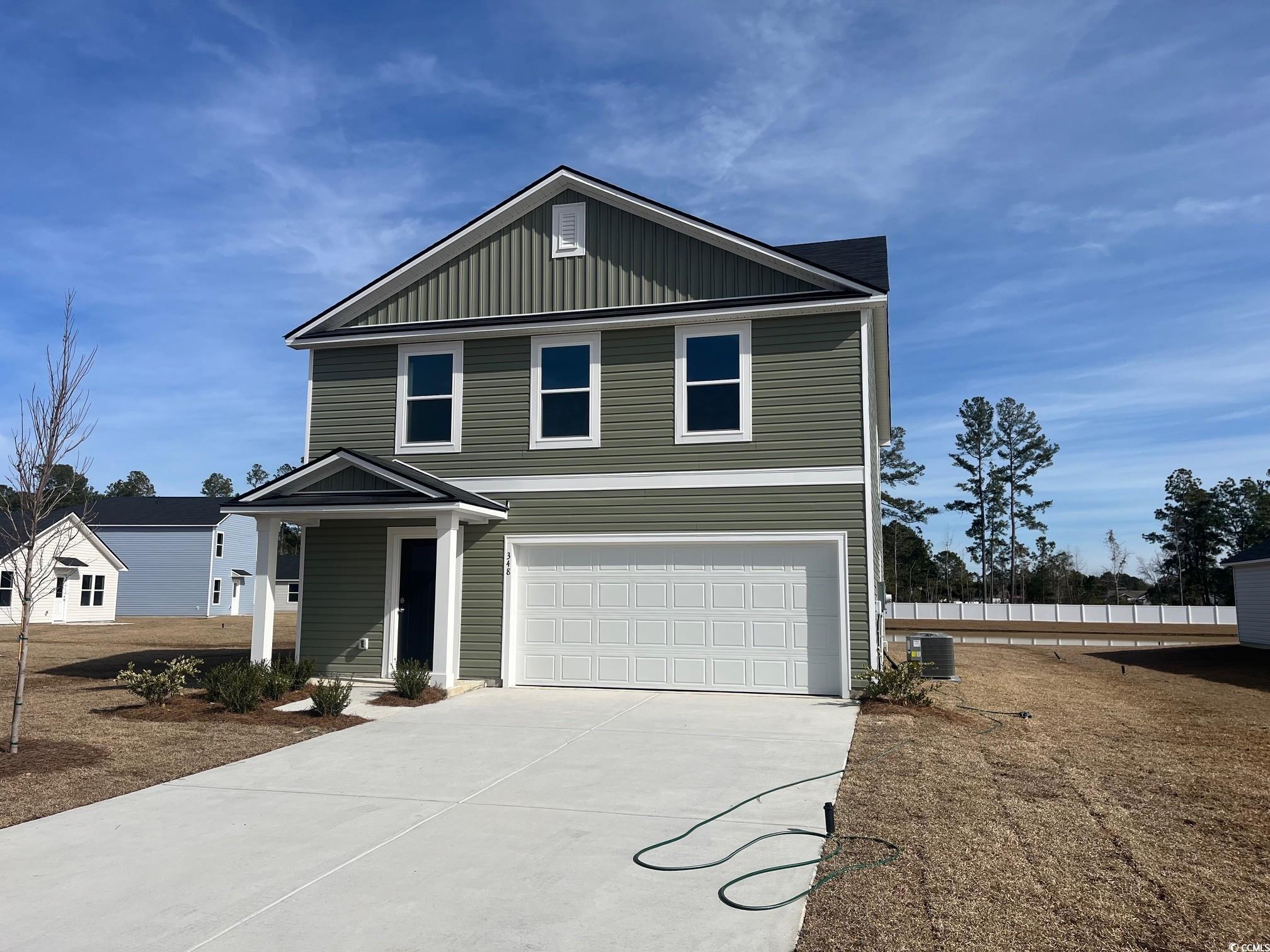 View of front of home featuring board and batten siding, concrete driveway, and a garage