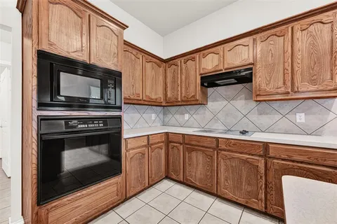 a kitchen with granite countertop a stove top oven microwave and cabinets