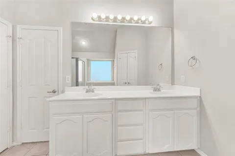 a bathroom with double sink and a mirror
