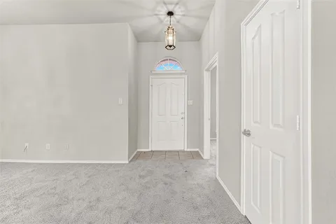 a view of a hallway with a chandelier fan