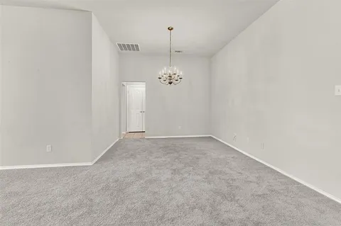 an empty room with chandelier and windows