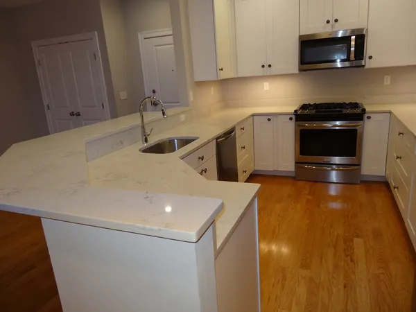 a kitchen with stainless steel appliances a stove a microwave a sink and cabinets