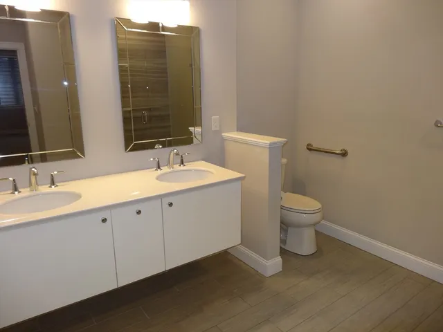 a bathroom with a toilet sink and mirror