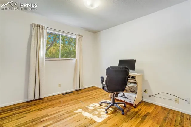 a view of a workspace with furniture and a window