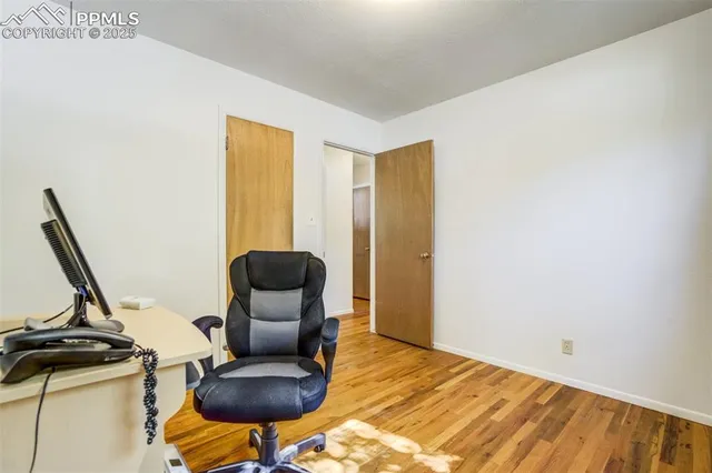 a view of a workspace with furniture and wooden floor