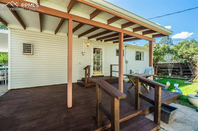 a view of a backyard with table and chairs under an umbrella
