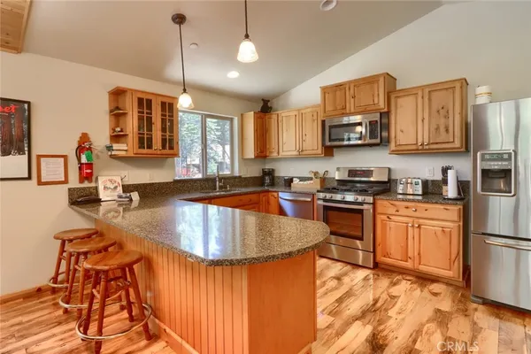 a kitchen with stainless steel appliances granite countertop a refrigerator a sink a stove a microwave and island