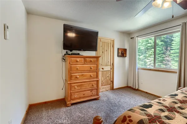 a bedroom with a bed a window and a chandelier