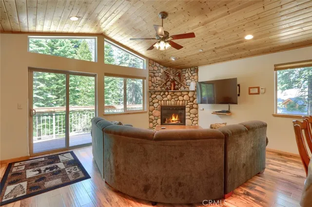 a dining room with wooden floor a chandelier a glass table and chairs
