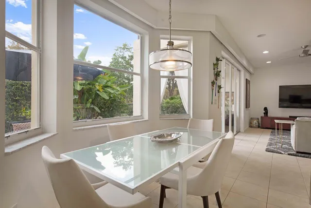 a dining room with wooden floor and a chandelier
