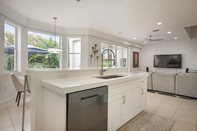 a kitchen with white cabinets and sink