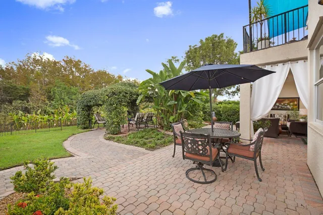 a view of a patio with table and chairs under an umbrella