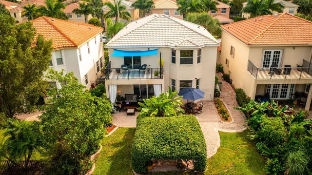 a front view of a house with a yard and potted plants