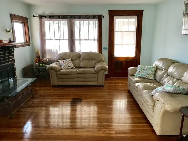 a living room with furniture window and wooden floor