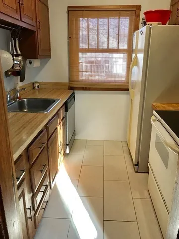 a kitchen with a sink a refrigerator and window