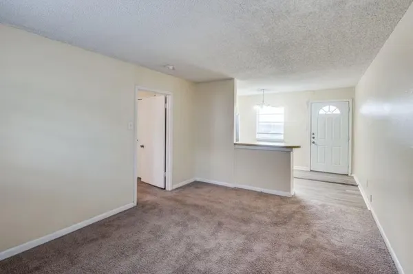 an empty room with a window and wooden floor