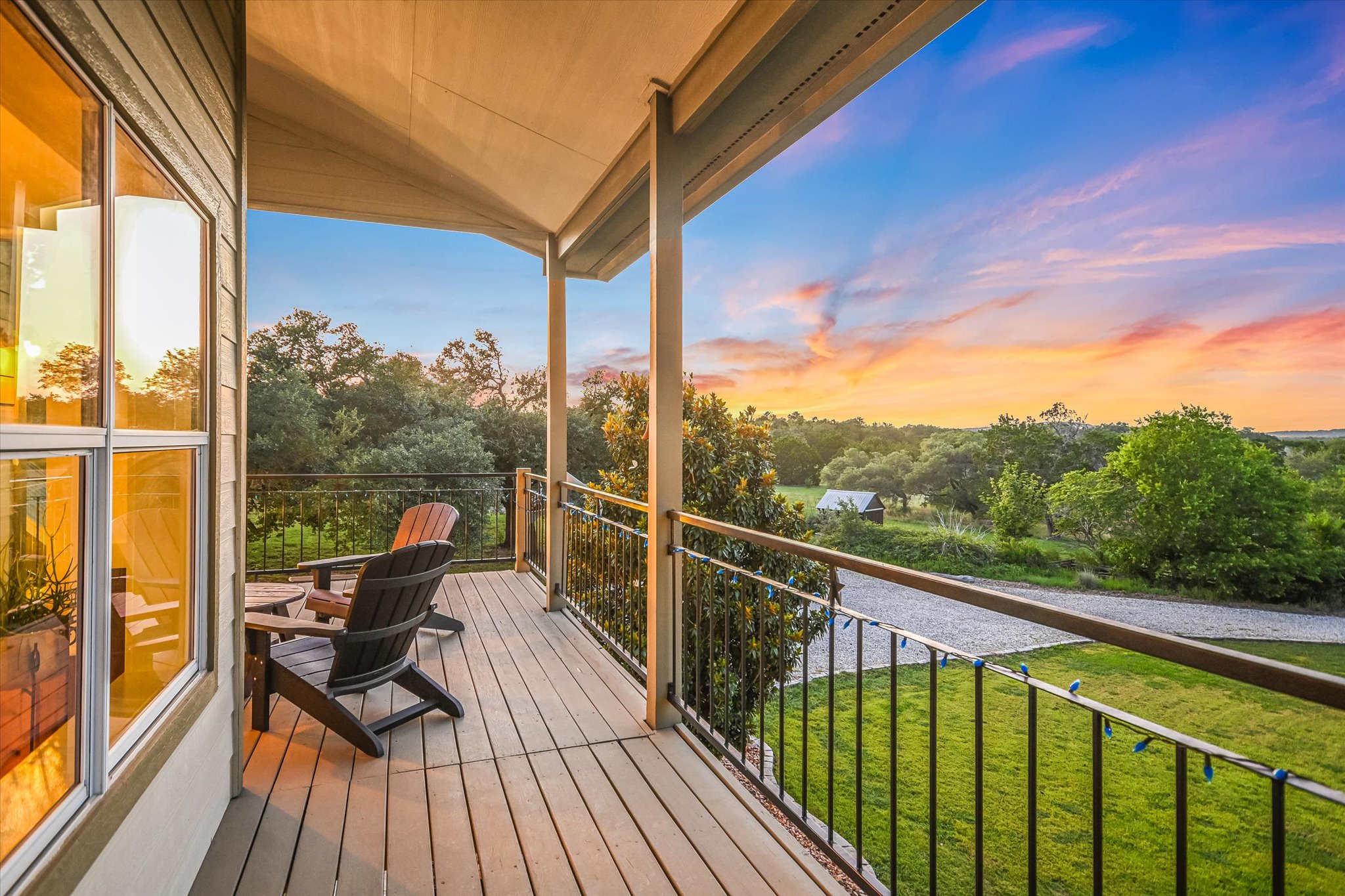 250 Hidden Oaks Road Wimberley, TX 78676 - Photo 2 of 40 a view of a balcony with chairs and wooden floor
